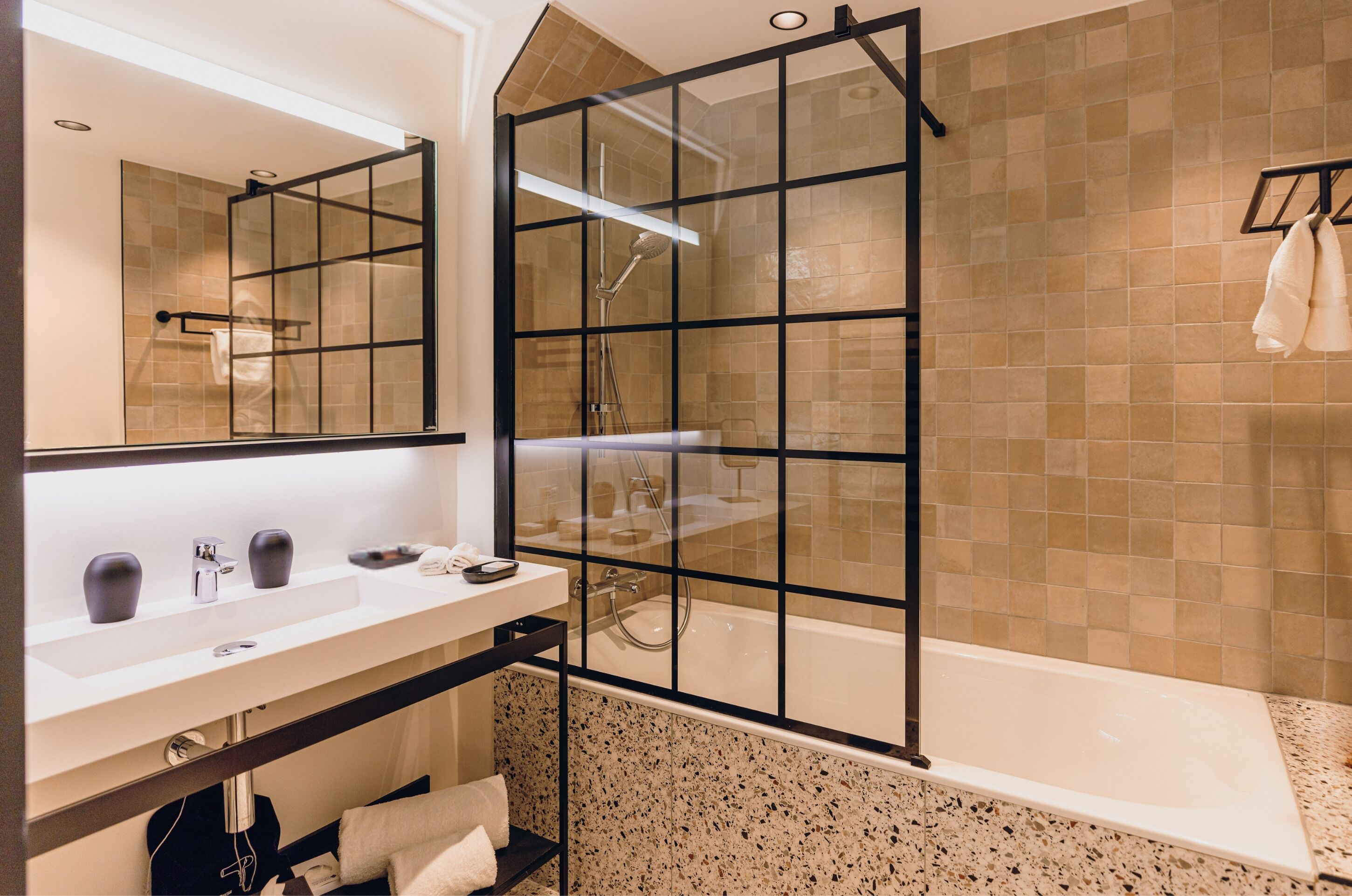 A modern bathroom with a glass shower enclosure, a white sink, and a bathtub.