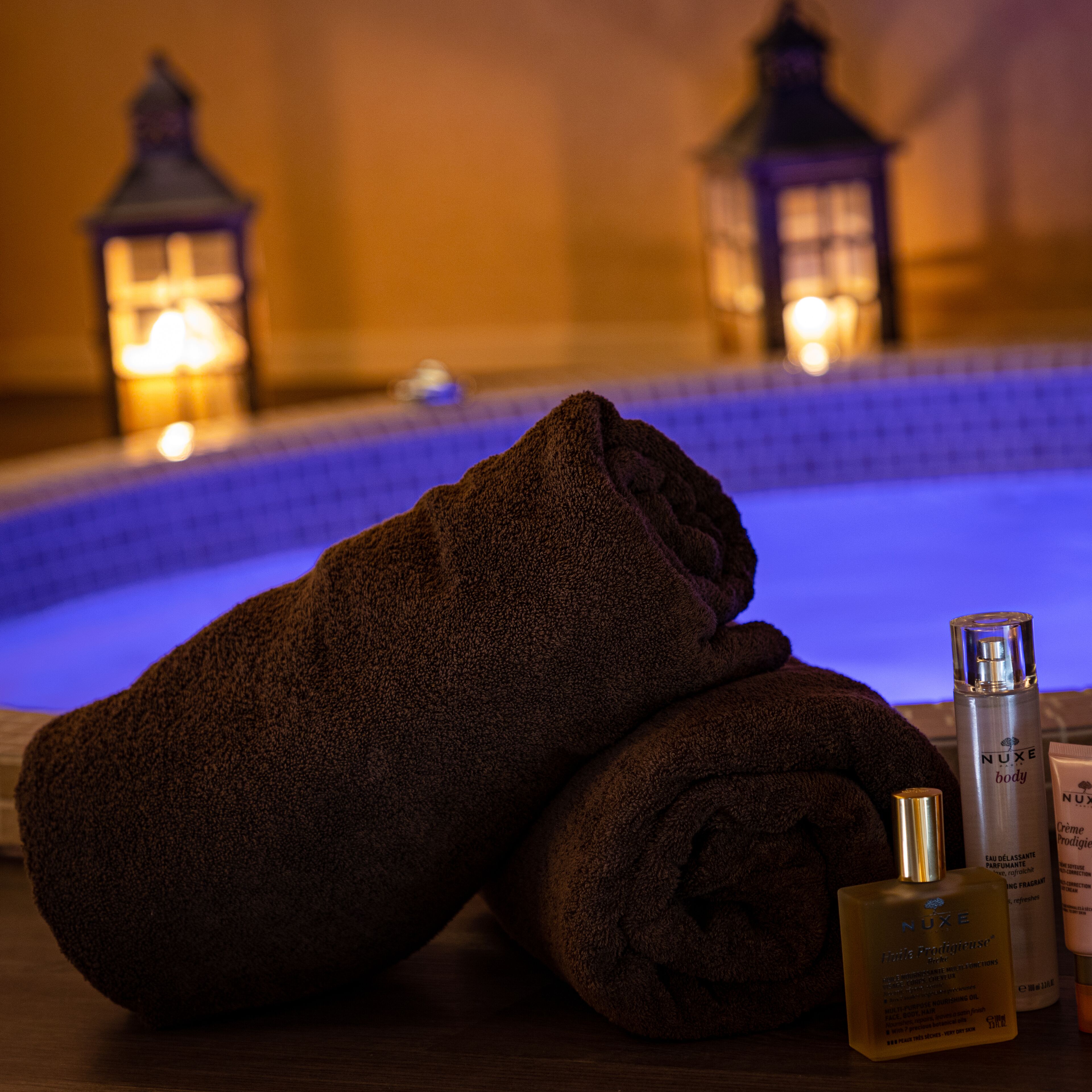 Ein Badezimmer mit Badewanne, Handtüchern und Pflegeprodukten.