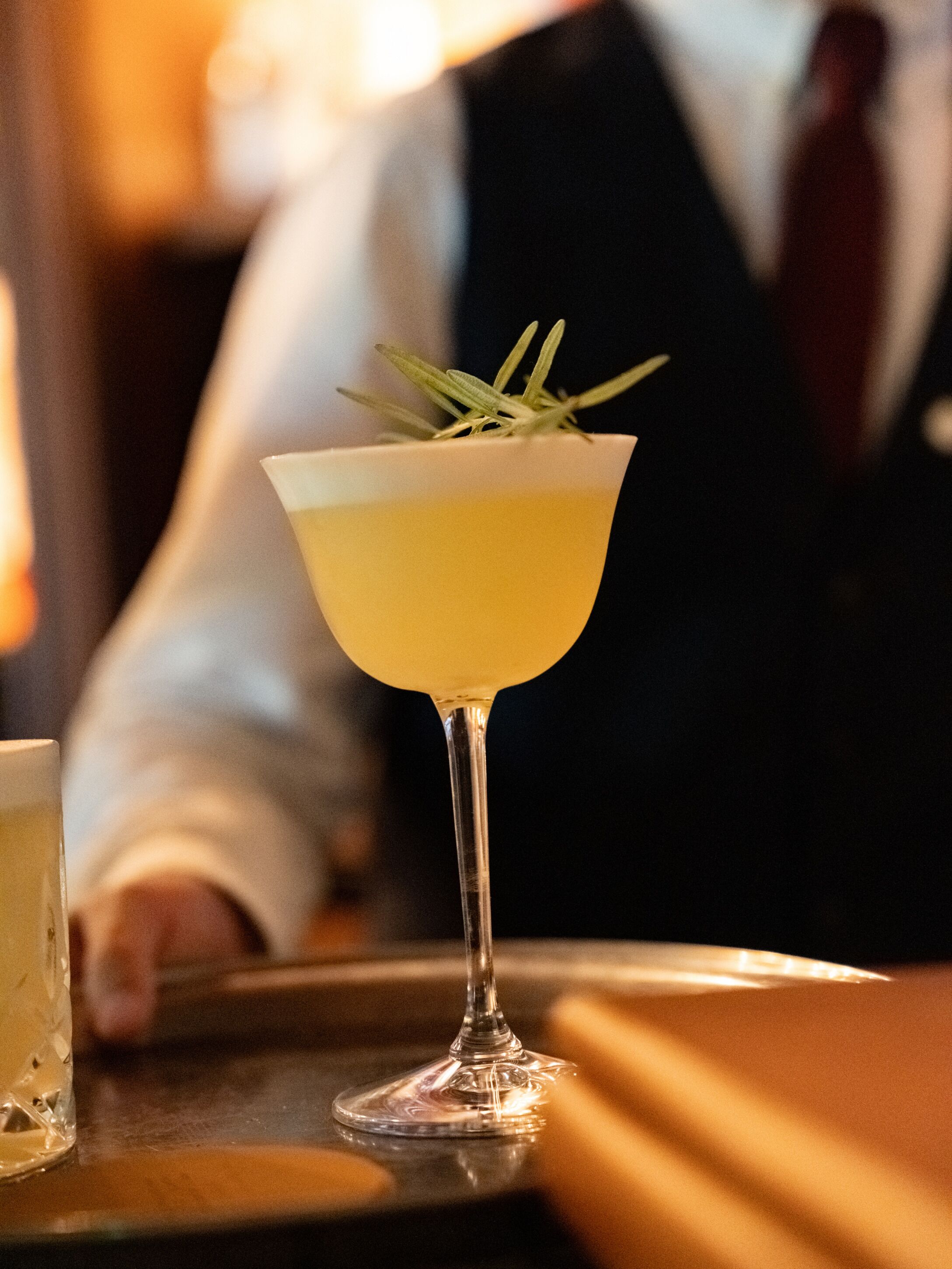 Et cocktailglas med pynt på et fad.