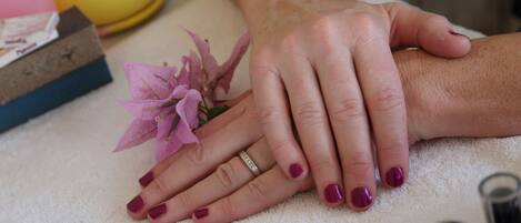 Une main posée sur une serviette, à côté d’une fleur et d’une boîte de mouchoirs.