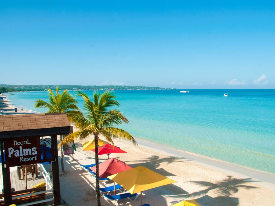 Na praia, espreguiçadeiras, guarda-sóis, toalhas de praia