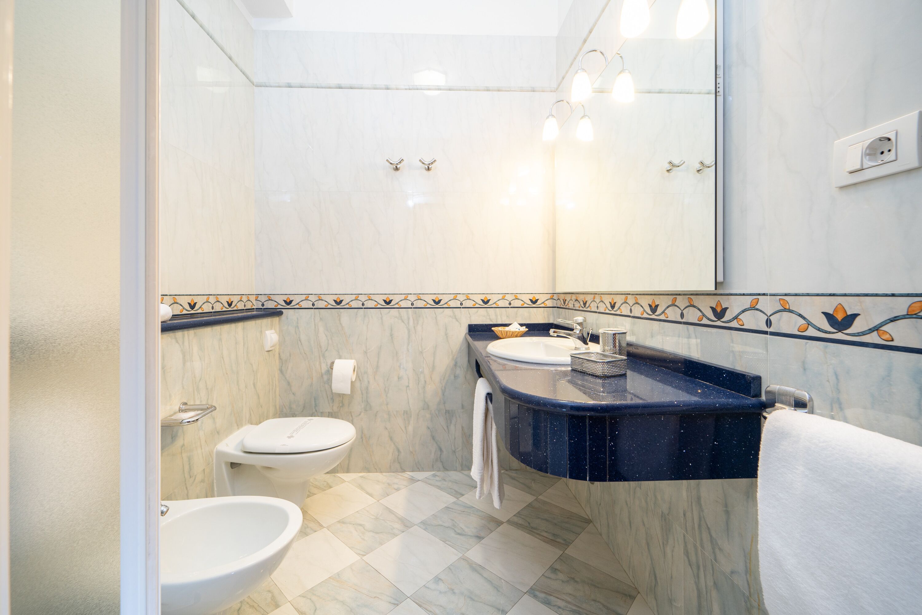 A bathroom with a toilet, bidet, and sink.