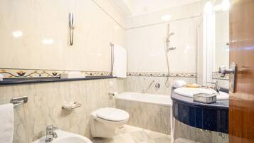 A bathroom with a bathtub, toilet, bidet, and sink.