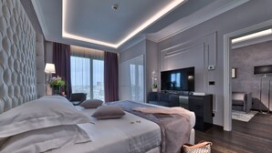 Une chambre d’hôtel moderne dotée d’un grand lit, d’un bureau, d’une télévision à écran plat et offrant une vue sur la ville.