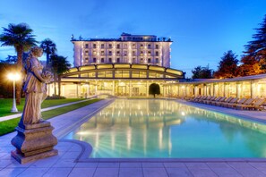 Et hotel med en pool, en statue og en bygning med flere etager og balkoner.
