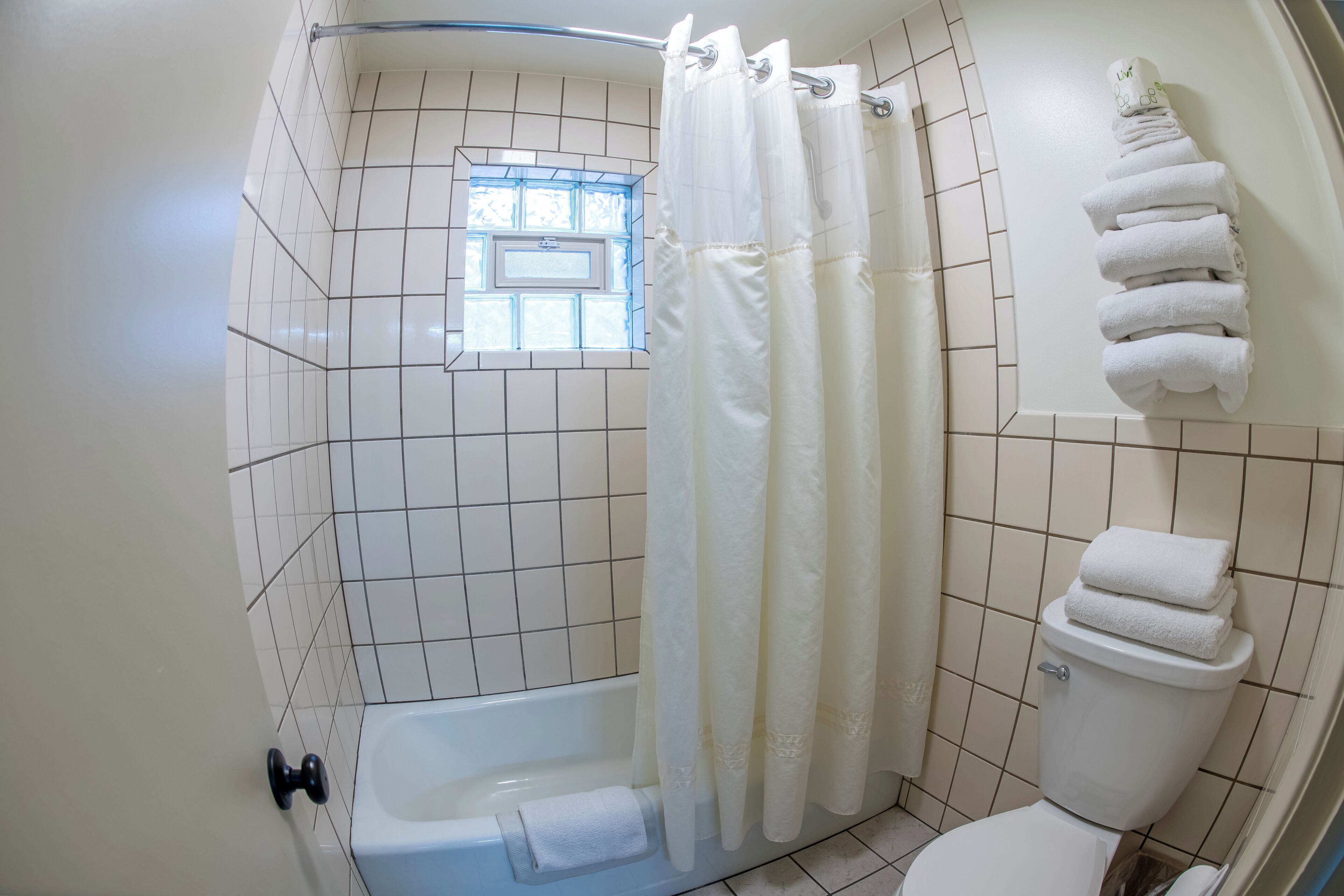 family suite, 2 full and 1 queen bed | bathroom | combined shower/bathtub, hair dryer, towels
