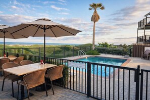 Una piscina al aire libre, sillones reclinables de piscina