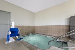 A small, rectangular hot tub with a blue chair and metal railings. - Best Western Plus Omaha Airport Inn (Carter Lake)