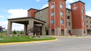 Best Western Plus -hotelli, jossa on katettu sisäänkäynti, kivestä ja tiilestä rakennettu julkisivu sekä kauniisti maisemoitu etupiha.