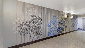 A hallway with a patterned wall and a wooden floor. - Best Western Plus Omaha Airport Inn (Carter Lake)