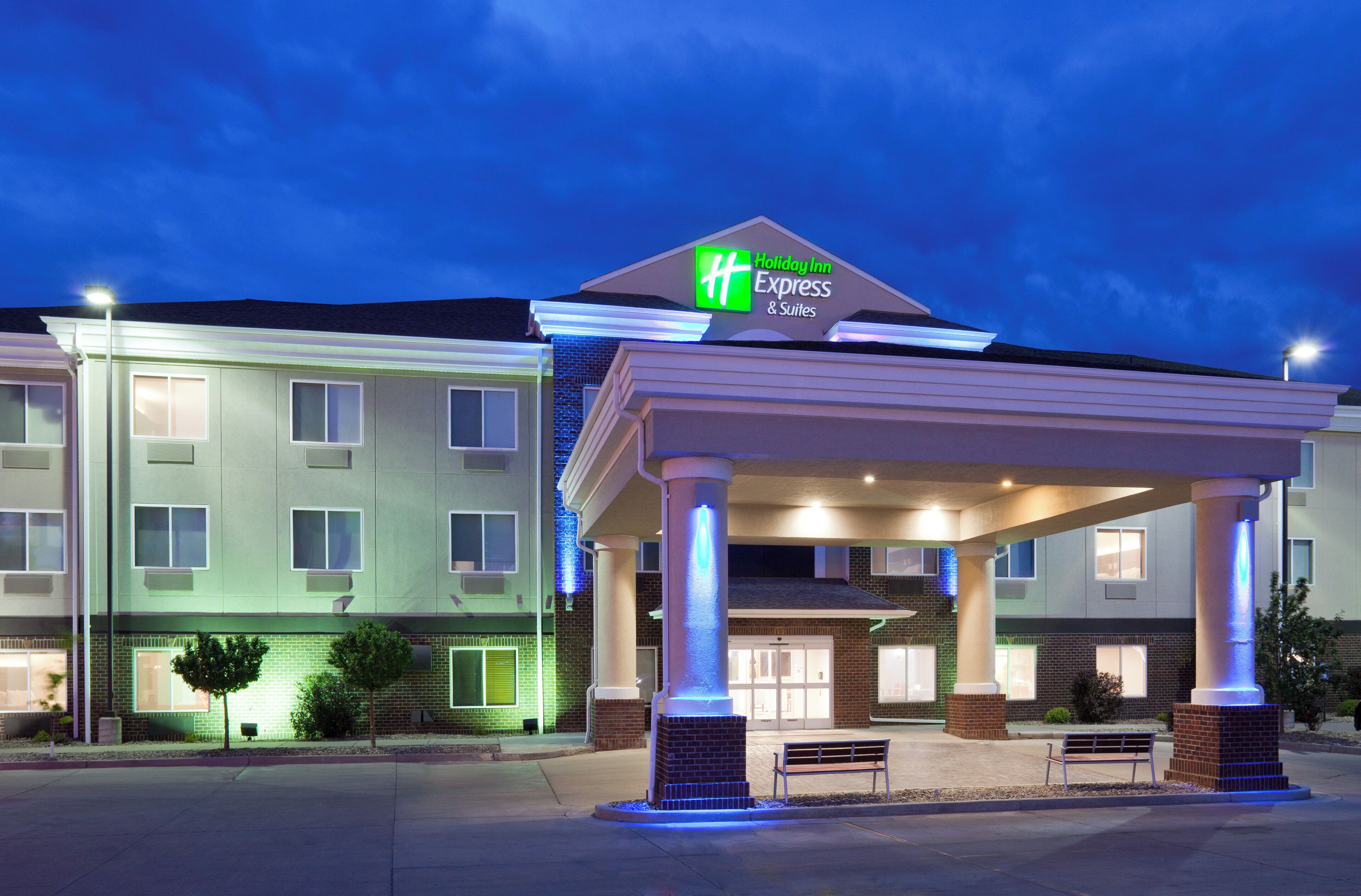 A Holiday Inn Express & Suites building with a covered entrance and a brick facade.