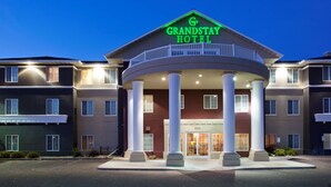 A hotel with a central entrance, columns, and a sign reading "GrandStay Hotel". - GrandStay Residential Suites - Eau Claire (Eau Claire)