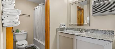 A bathroom with a toilet, sink, and shower.
