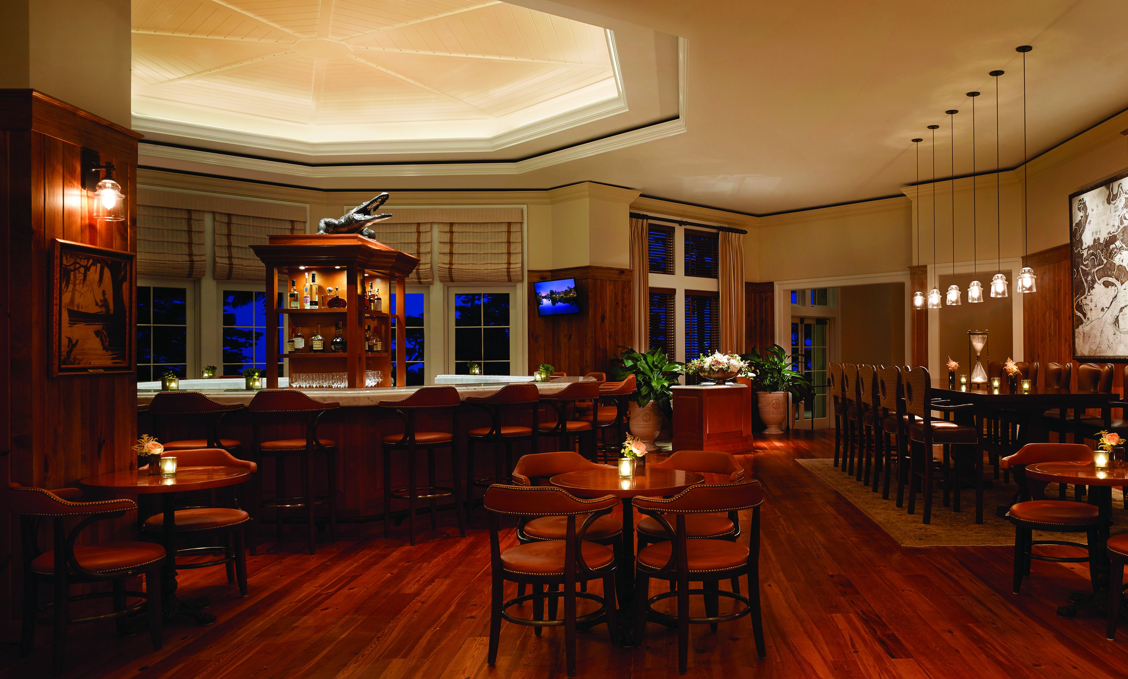 A bar area with wooden furniture, a television, and a ceiling skylight.