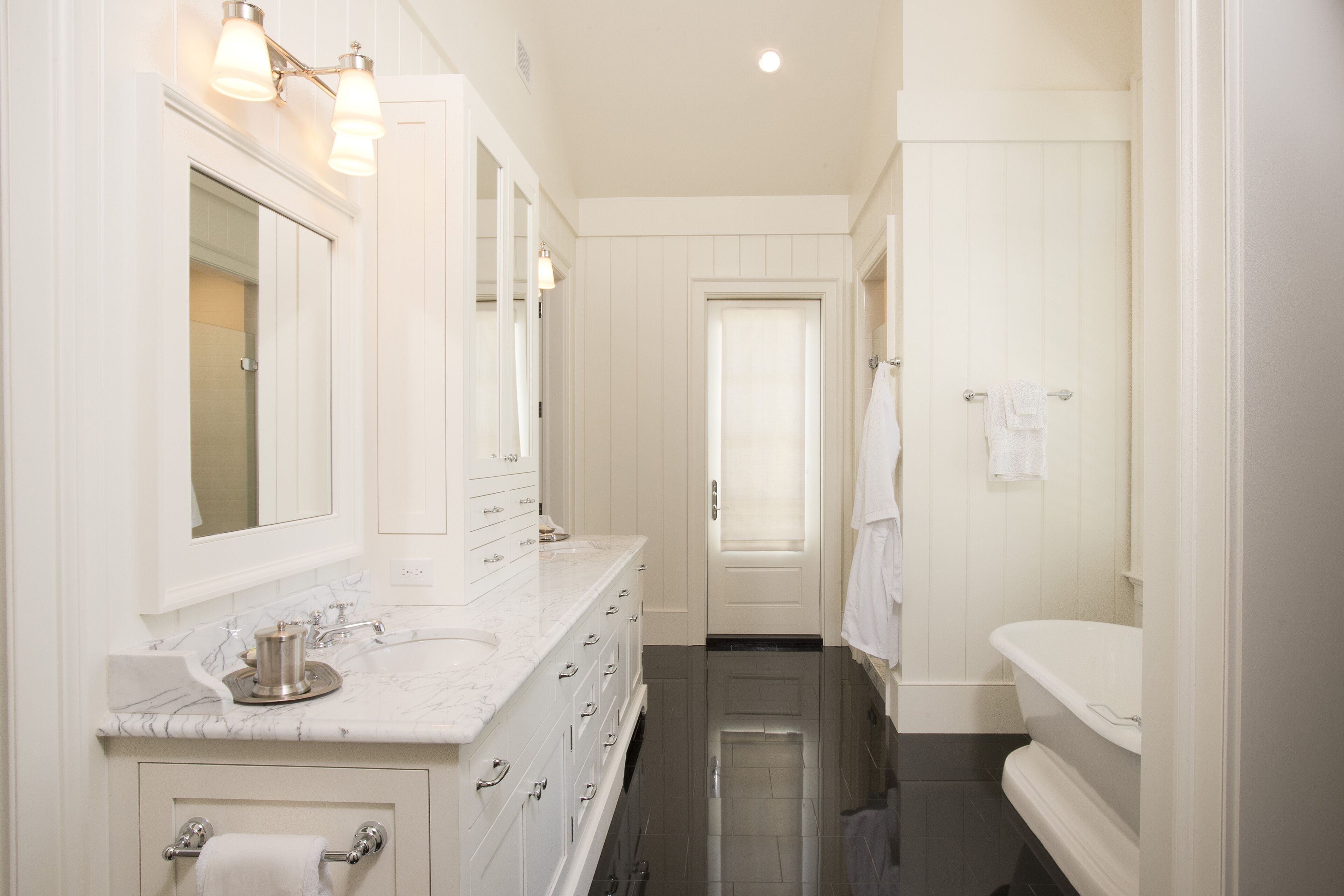 A modern bathroom with a large vanity, a bathtub, and a shower.