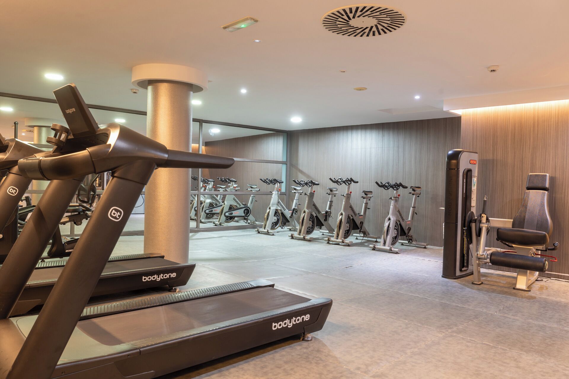 A gym with treadmills, stationary bikes, and a rowing machine.