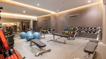 Ein modernes Fitnessstudio mit verschiedenen Trainingsgeräten, darunter Laufbänder, Kraftgeräte und Kurzhanteln.