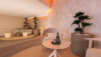 Uma sala de estar moderna com um sofá, uma mesa redonda e plantas decorativas.