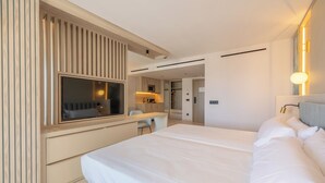 Une chambre d’hôtel moderne avec un grand lit, un bureau et une télévision.
