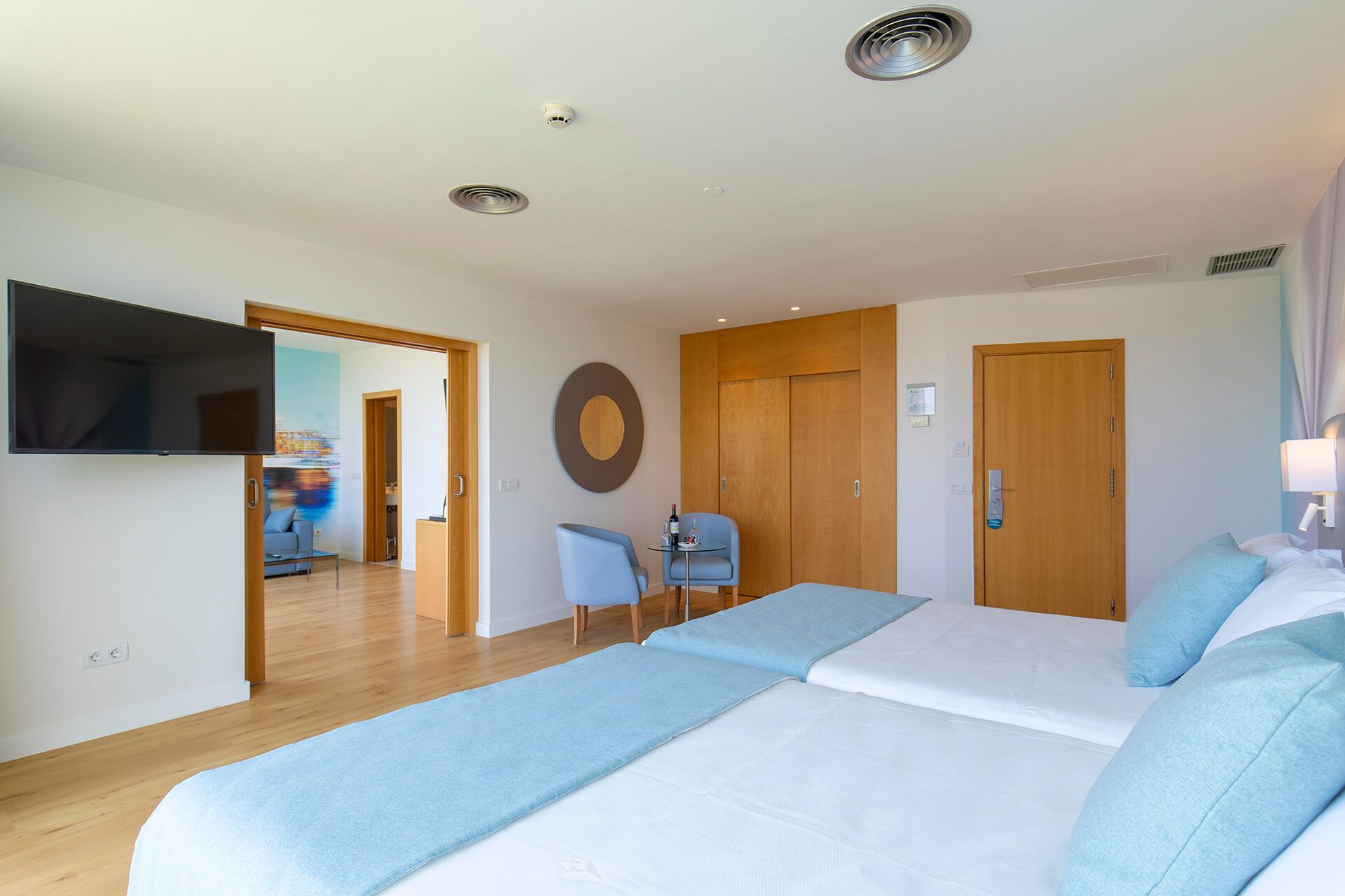 A hotel room with a bed, a TV, a desk, and a chair.