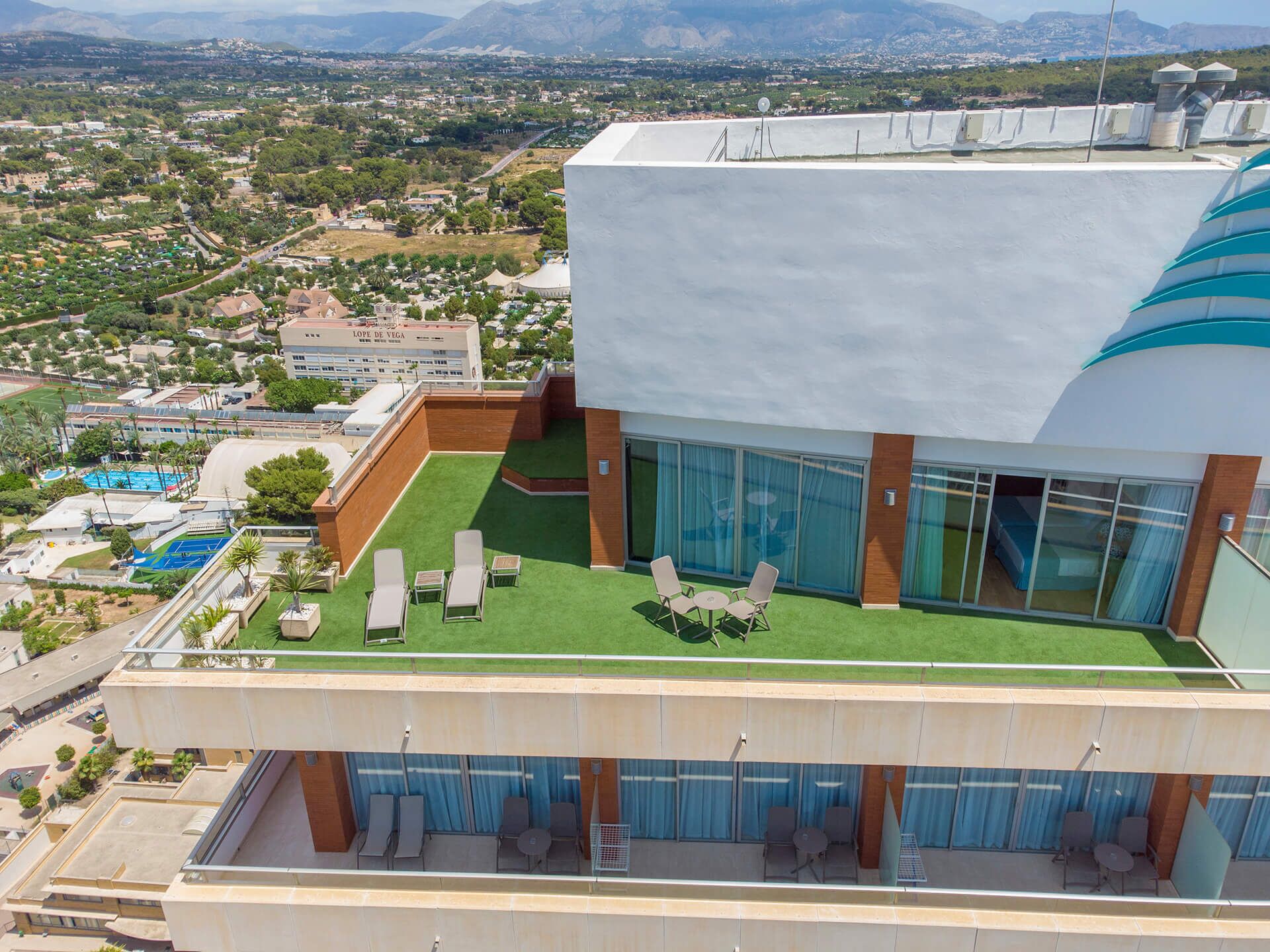 A rooftop terrace with outdoor seating and a view of the surrounding cityscape.