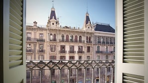 Een uitzicht op een historisch gebouw met versierde architectuur, waaronder meerdere balkons en een opvallende toren.