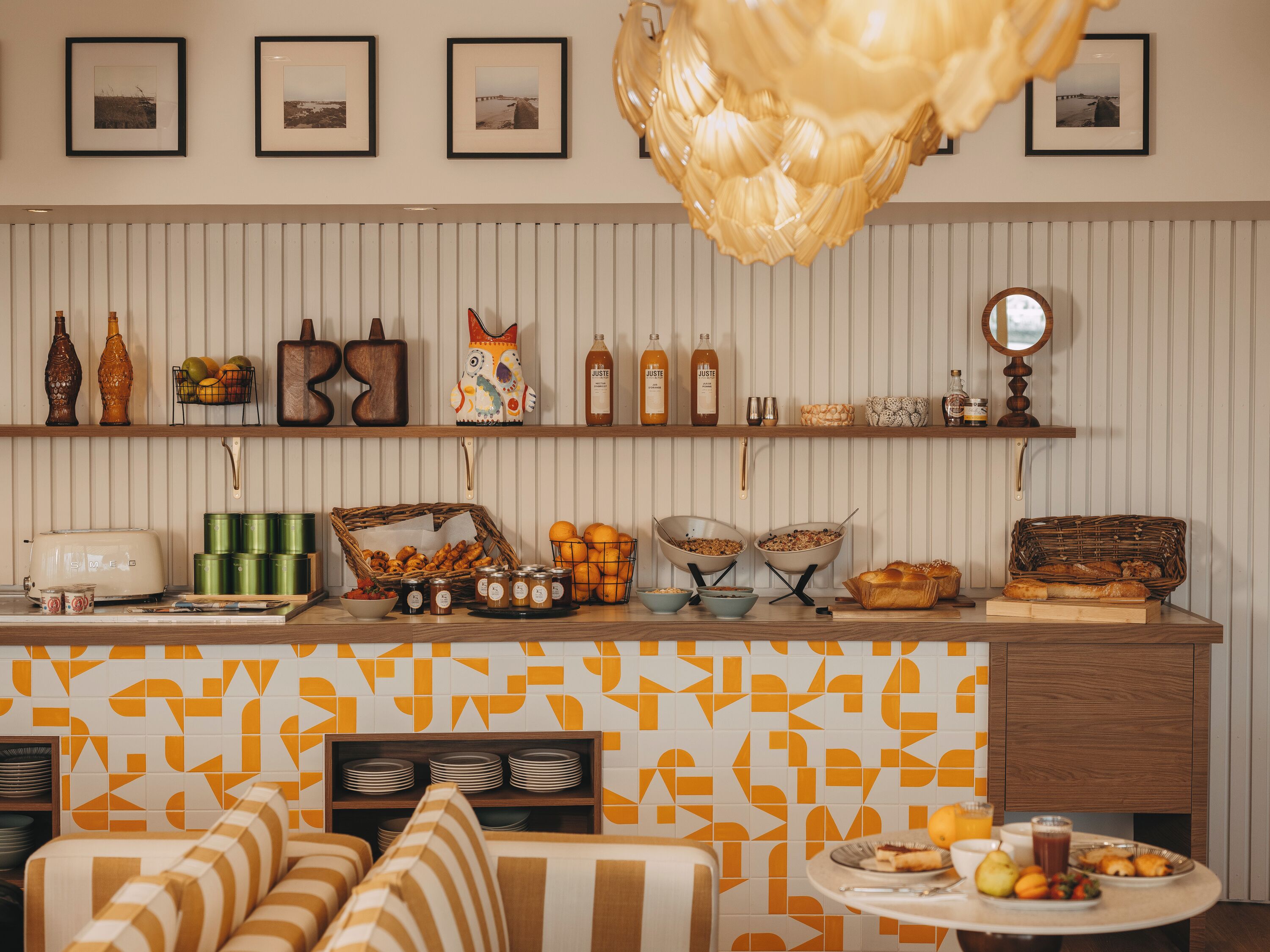A kitchen with a striped wall, a hanging light fixture, and various kitchen items on shelves.