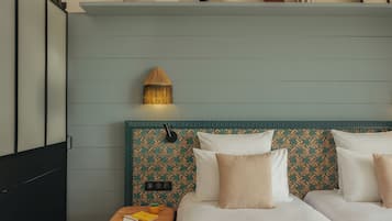 Quarto com cama, mesa de cabeceira, abajur e objetos decorativos em uma estante.