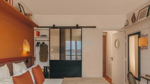Een hotelkamer met een bed, een kledingkast, een spiegel, een bureau en een stoel.