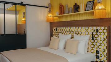 Une chambre d’hôtel avec un lit, une table de chevet et une étagère ornée d’objets décoratifs.