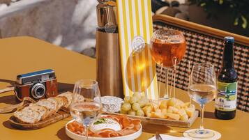 A table set with food and drinks, a camera, and a bottle of wine.