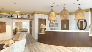 Een receptie met een gebogen houten balie, pendelverlichting van riet en een zithoek met comfortabele stoelen.