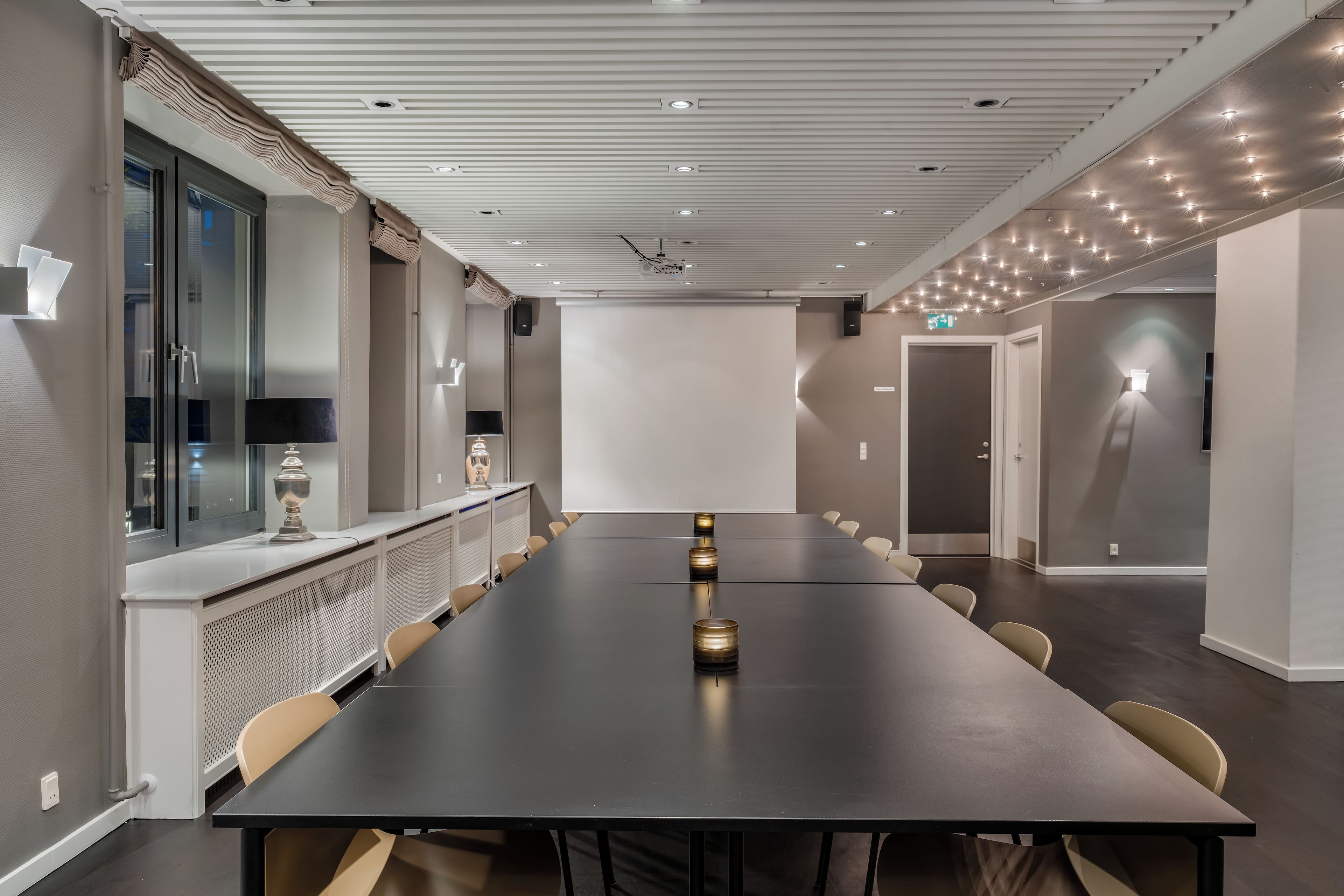 Ein Konferenzraum mit einem langen Tisch, Stühlen und einer Whiteboard-Tafel.