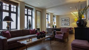 Amplia sala de estar con sofá, sillones, una mesita de centro y chimenea.
