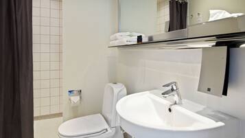 A modern bathroom with a toilet, sink, and mirror.