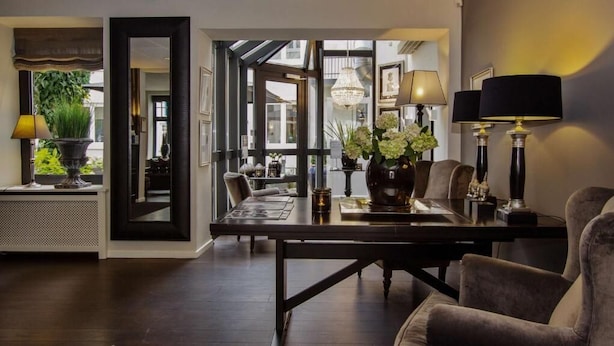 Un comedor moderno con una mesa de madera oscura, asientos cómodos y lámparas decorativas.