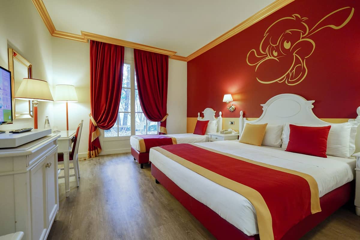 Une chambre d’hôtel avec deux lits, un bureau et une chaise.