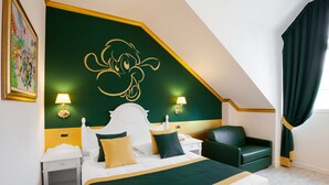 A hotel room with a large bed, two bedside tables, a green armchair, and a painting on the wall. - Gardaland Hotel (Castelnuovo del Garda)