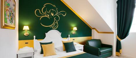A hotel room with a large bed, two bedside tables, a green armchair, and a painting on the wall.