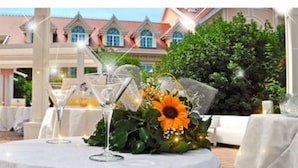 A table set for a formal event with a floral centerpiece and a glass of champagne. - Gardaland Hotel (Castelnuovo del Garda)