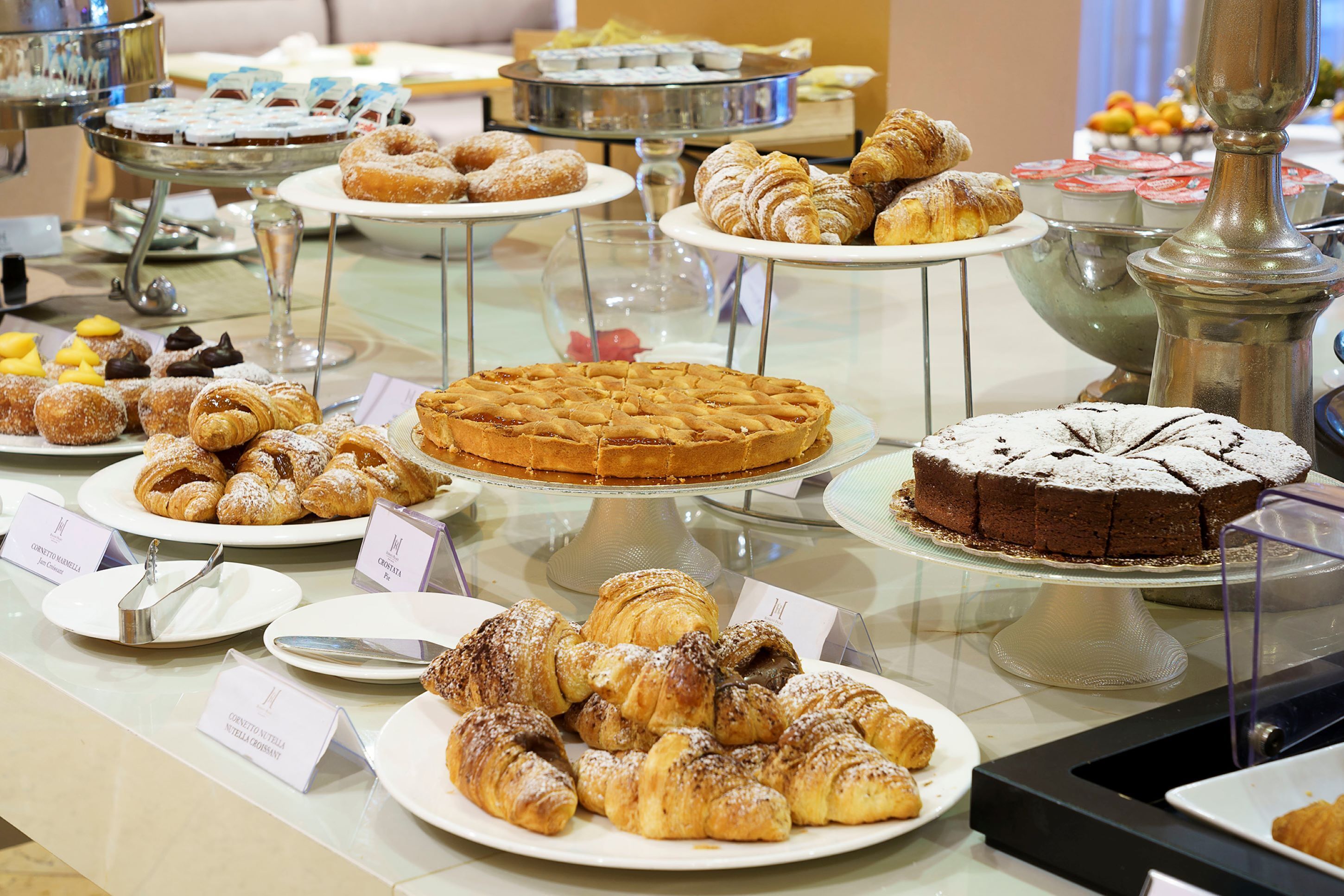 A buffet with various pastries and desserts on display.