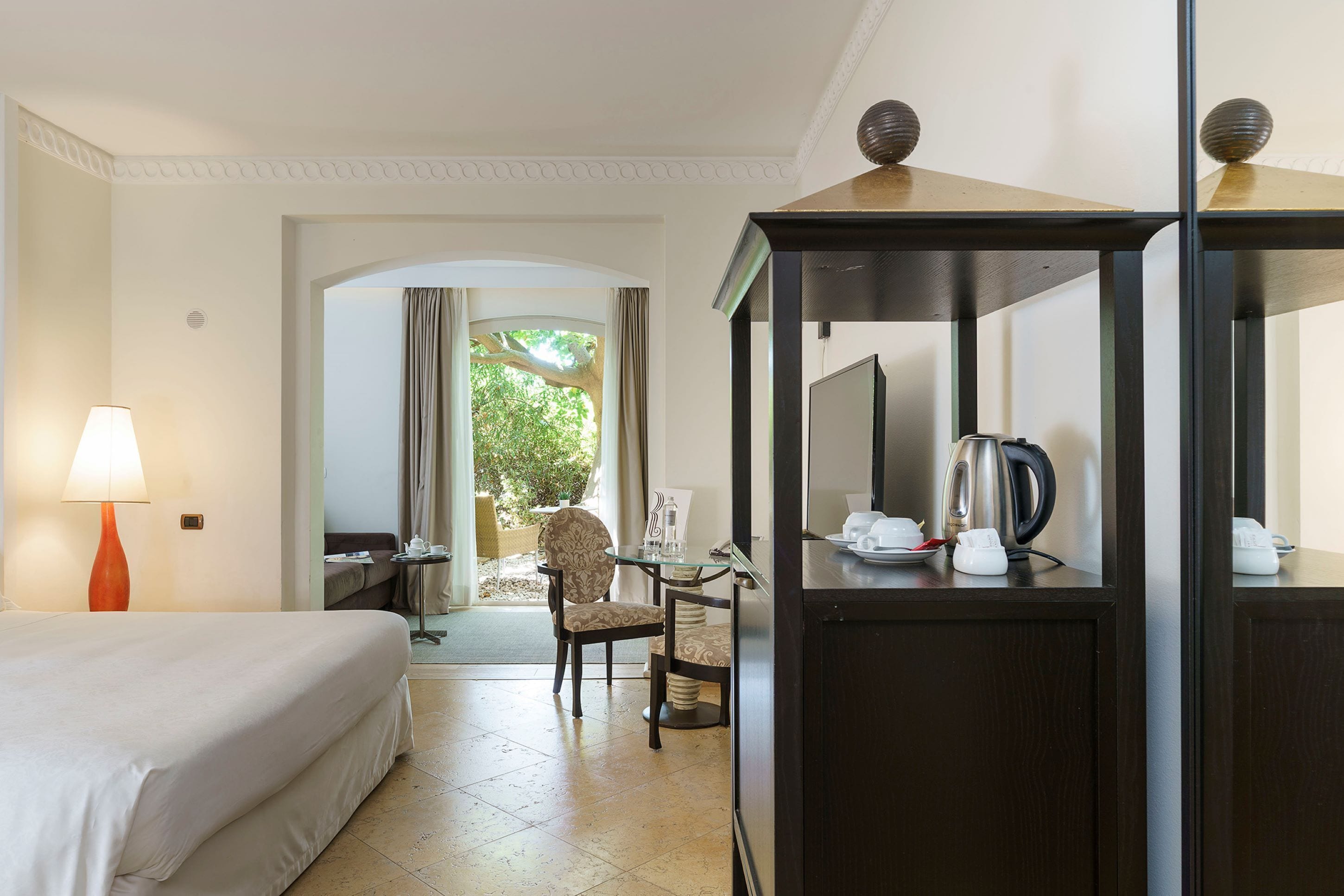 Une chambre d’hôtel comprenant un lit, un bureau avec une chaise, une machine à café et une vue sur l’extérieur.