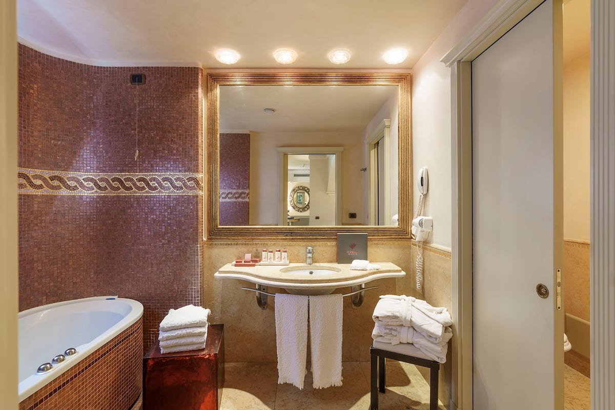 luxury suite, balcony | bathroom | rainfall showerhead, designer toiletries, hair dryer, slippers