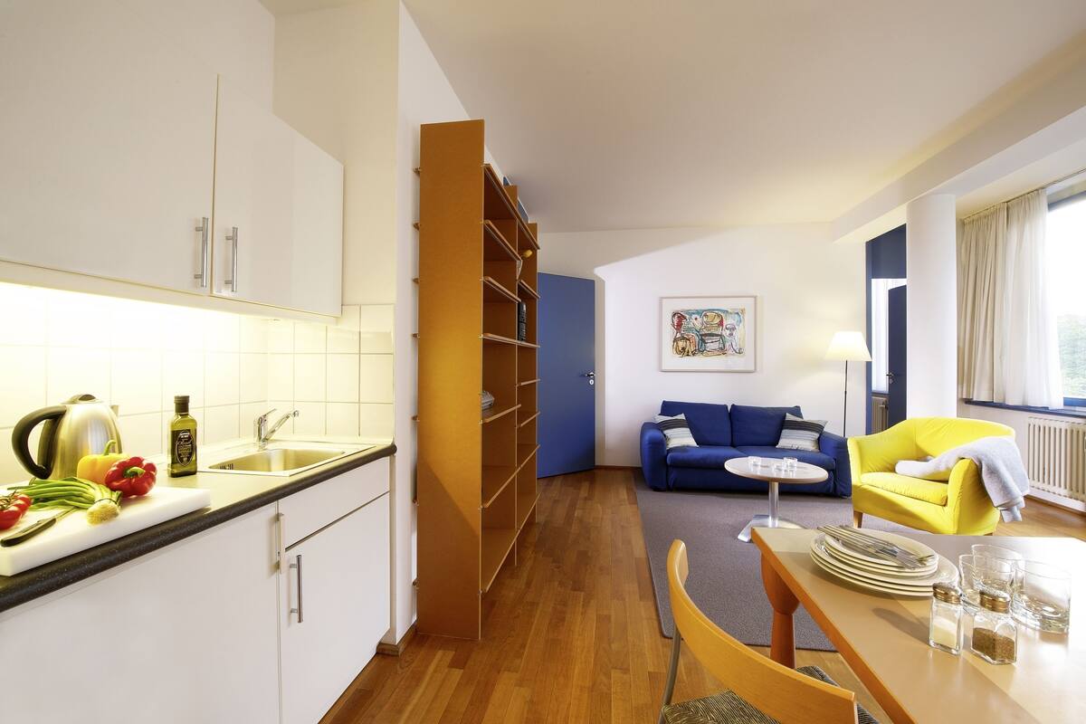 Un espacio habitable compacto con cocina, comedor y sofá.