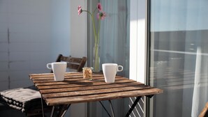 A wooden table with two white cups and a glass jar with flowers. - Hotel Medo Köln (Cologne)