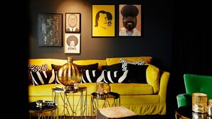 A room with a yellow sofa, a green armchair, and a table with decorative items. - Hotel Medo K öln (Cologne)