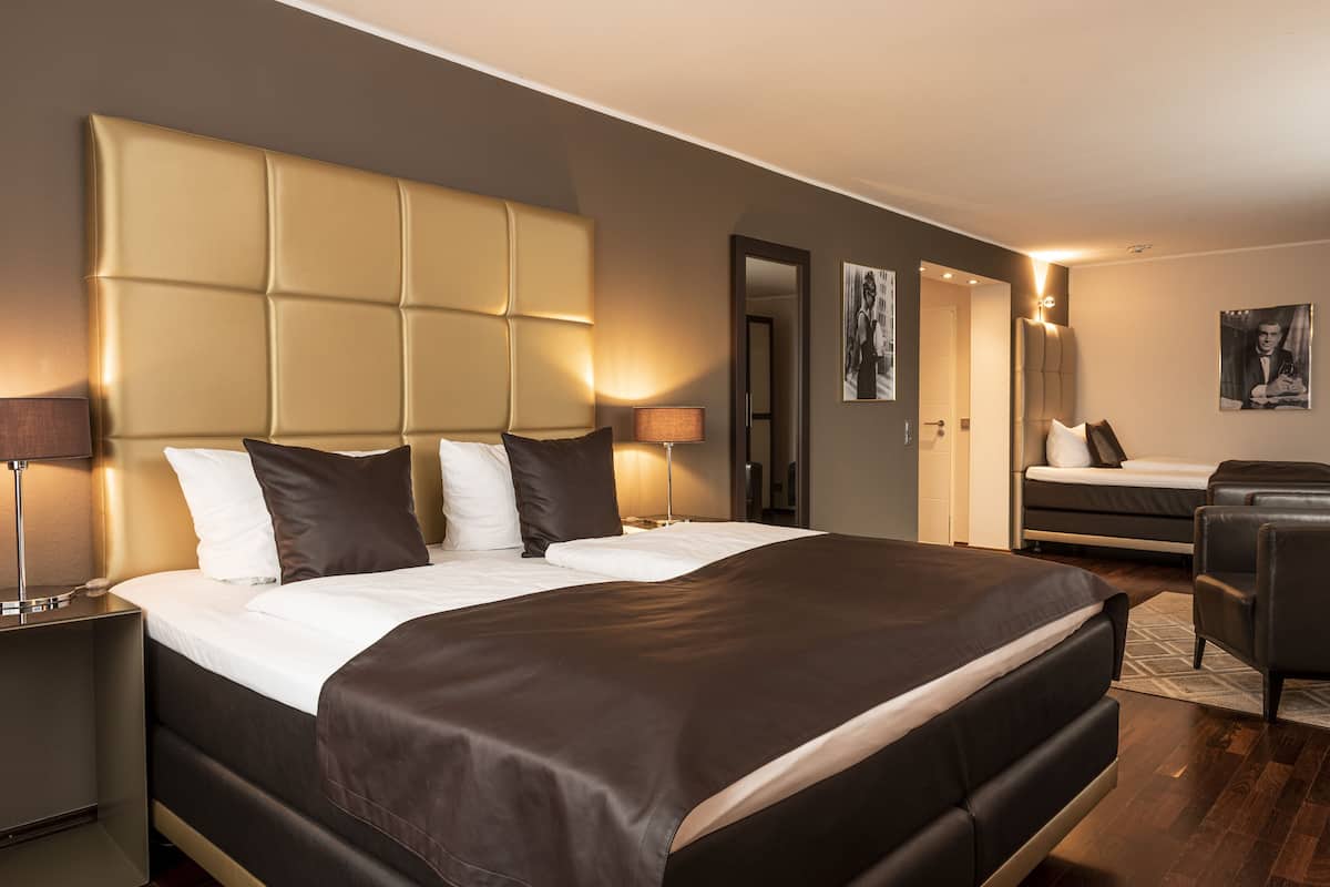 Une chambre d’hôtel moderne, dotée d’un grand lit, d’un canapé, d’un bureau et d’une chaise.