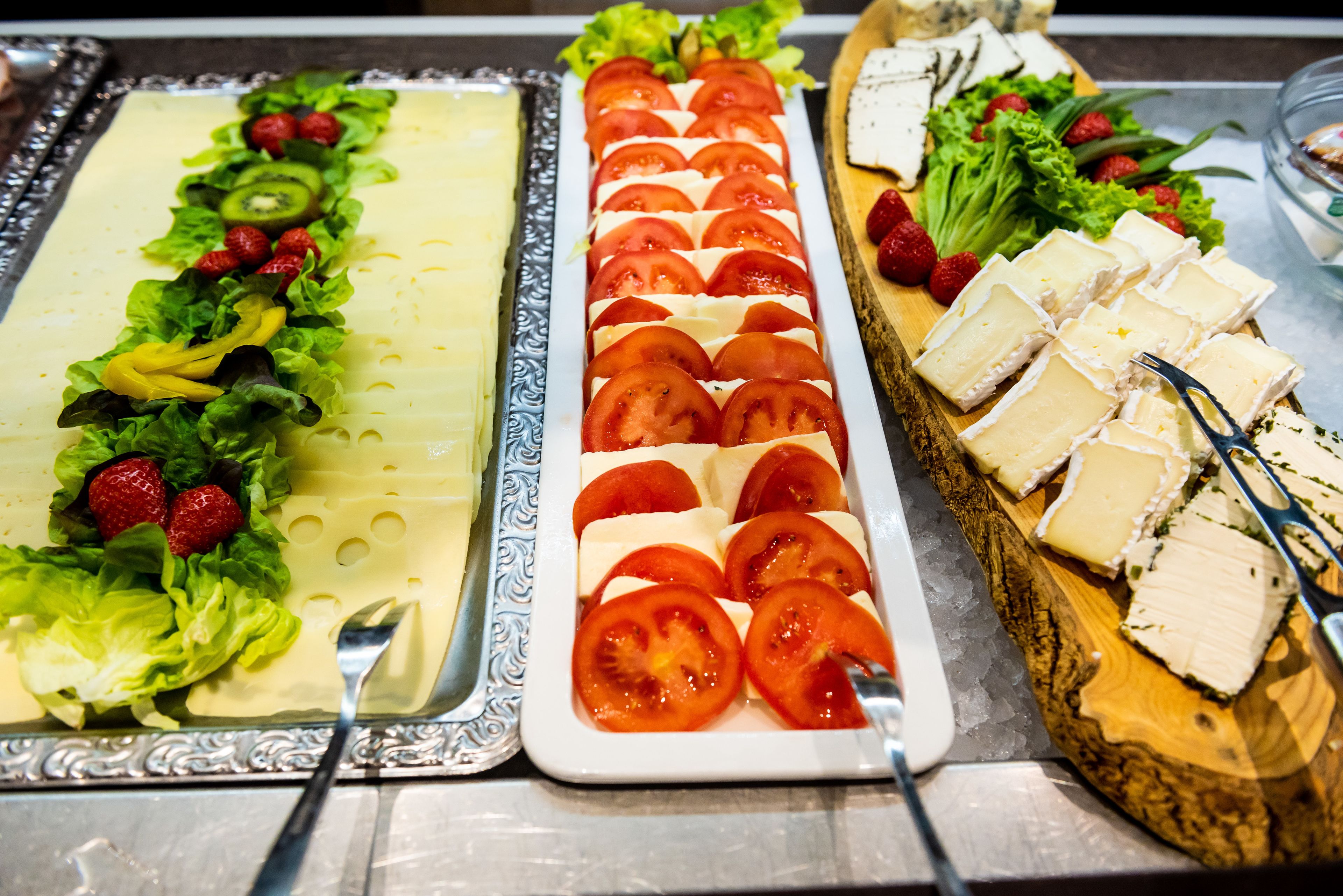 Ein reichhaltiges Buffet mit verschiedenen Speisen, darunter Käse, Tomaten und Erdbeeren.