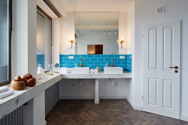 A bathroom with two sinks, a large mirror, and a door. - hotel friends Düsseldorf Downtown (Düsseldorf)