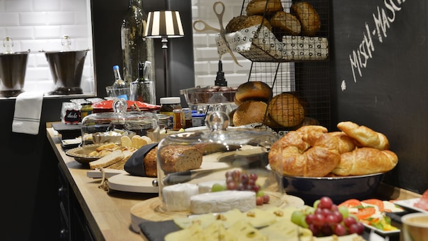 Buffetpöydässä on tarjolla monenlaista ruokaa, kuten leipää, juustoa ja hedelmiä.